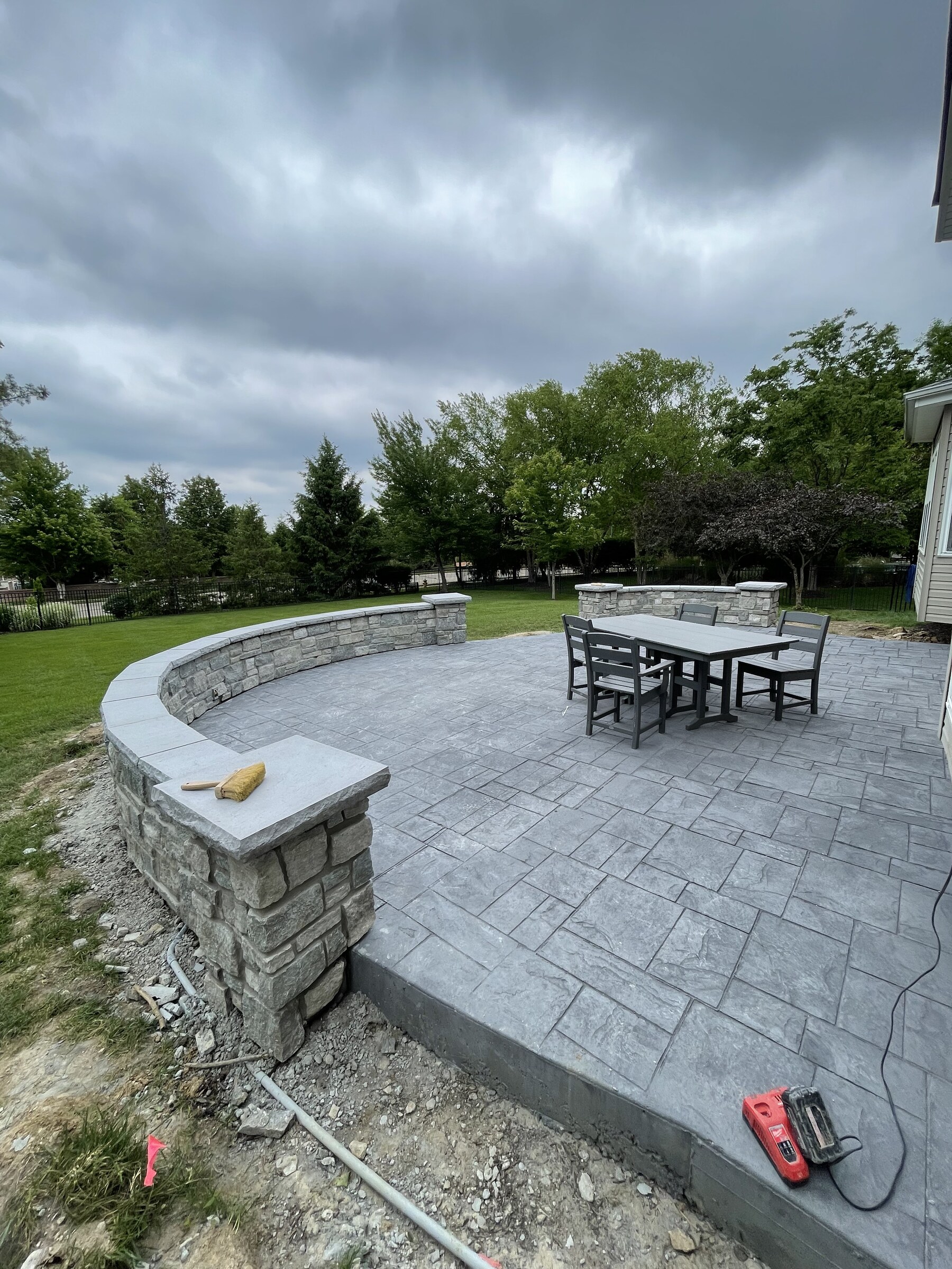Curved natural stone masonry patio and seat wall